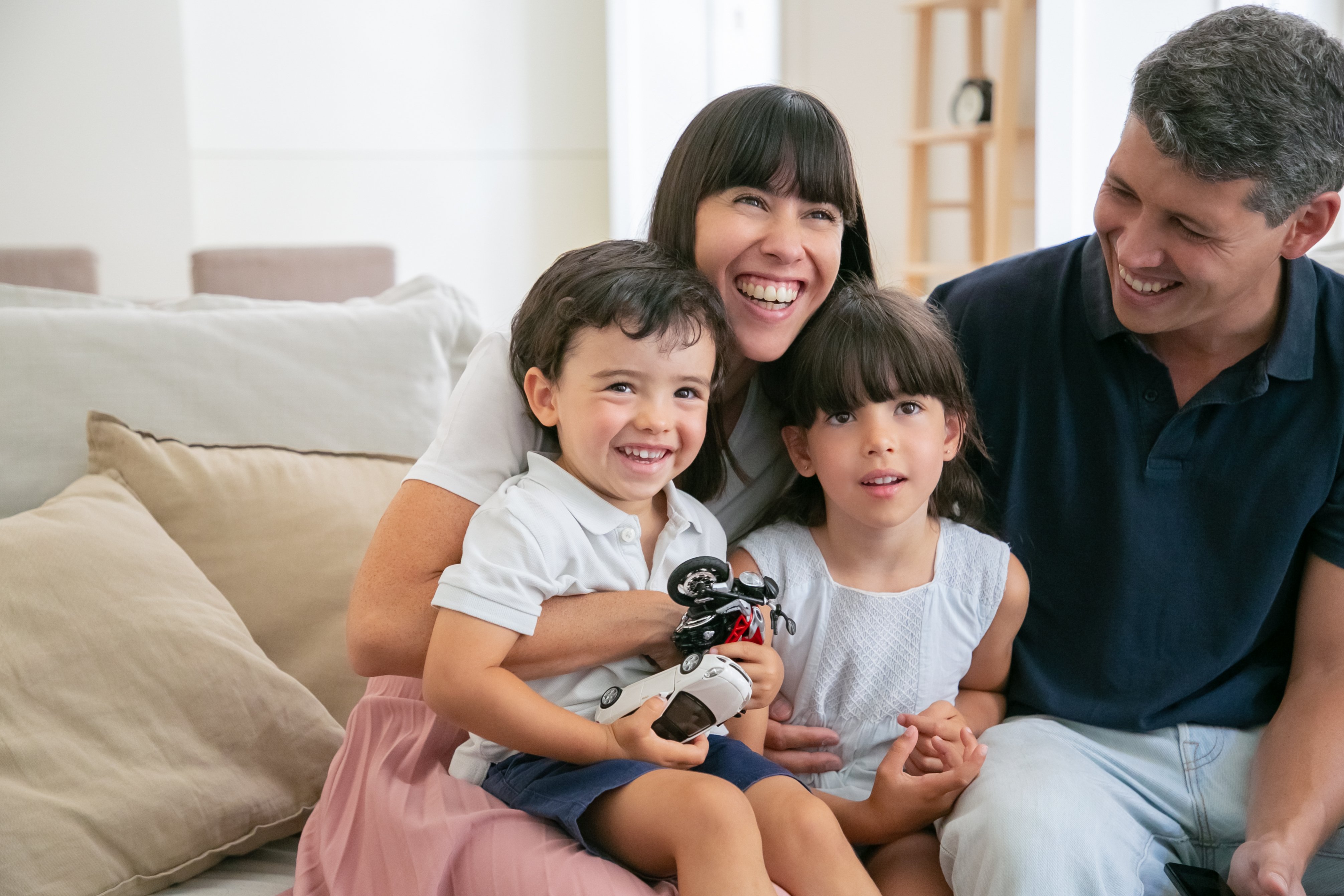 cheerful-funny-parents-and-two-kids-watching-funny-movie-at-home-sitting-on-couch-in-living-room-and-looking-away-and-laughing-jpg